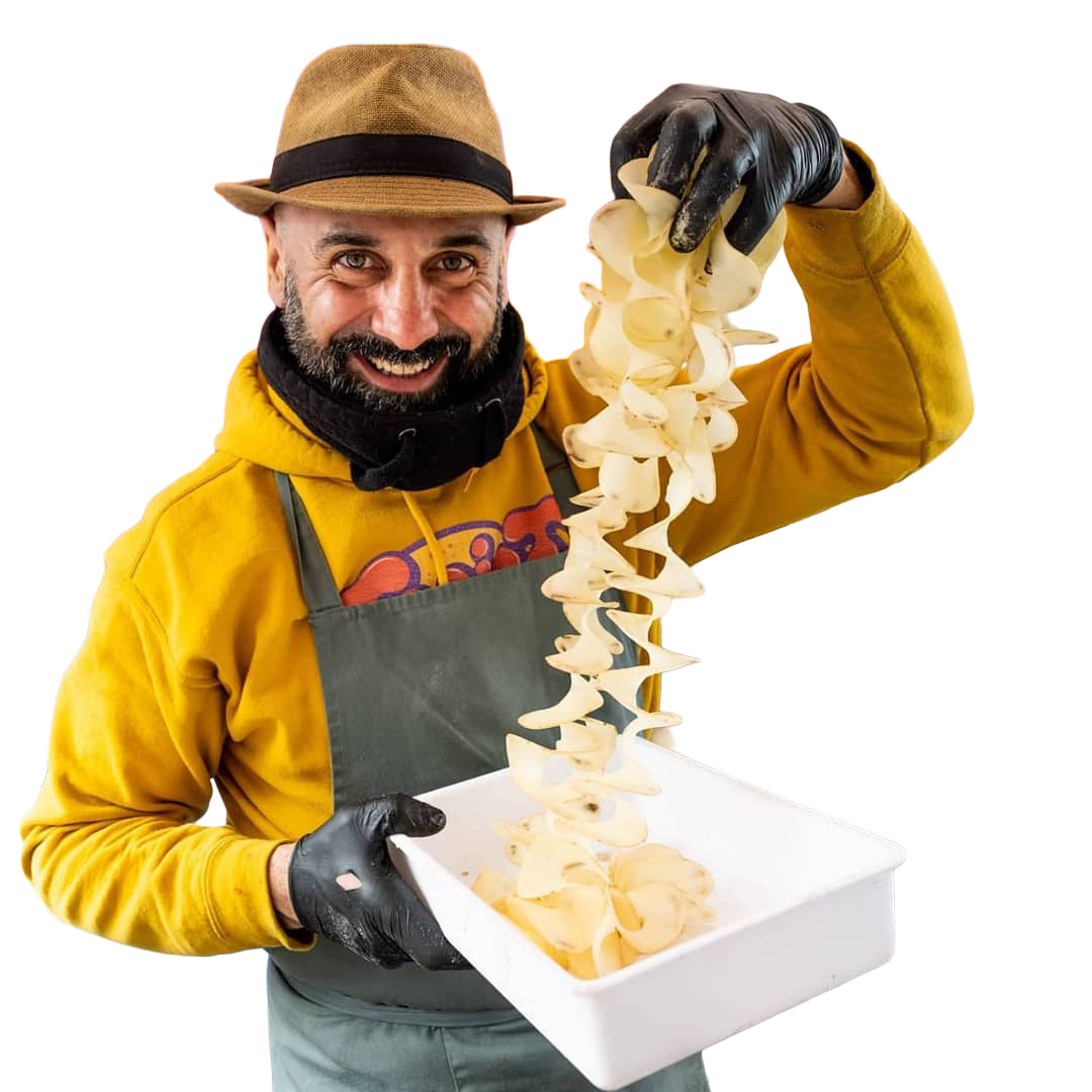 Marcello holding a spiral of hand-cut potato crisps over a tray